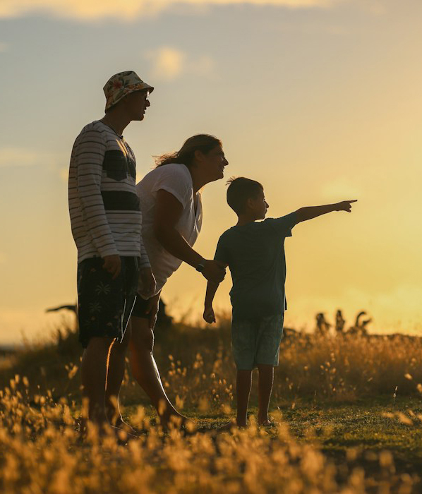 Couple walking through a field at sunrise